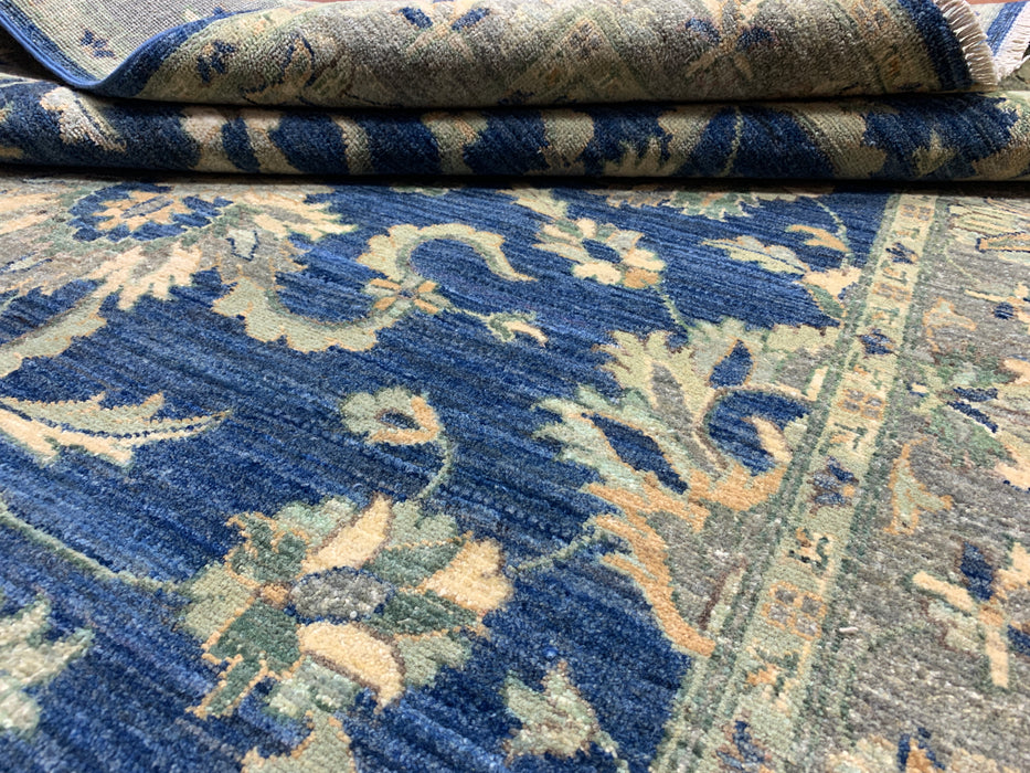 147 × 198 cm handgeknoopt wollen tapijt – marineblauw met bloemrijke rand in zacht beige en saliegroen