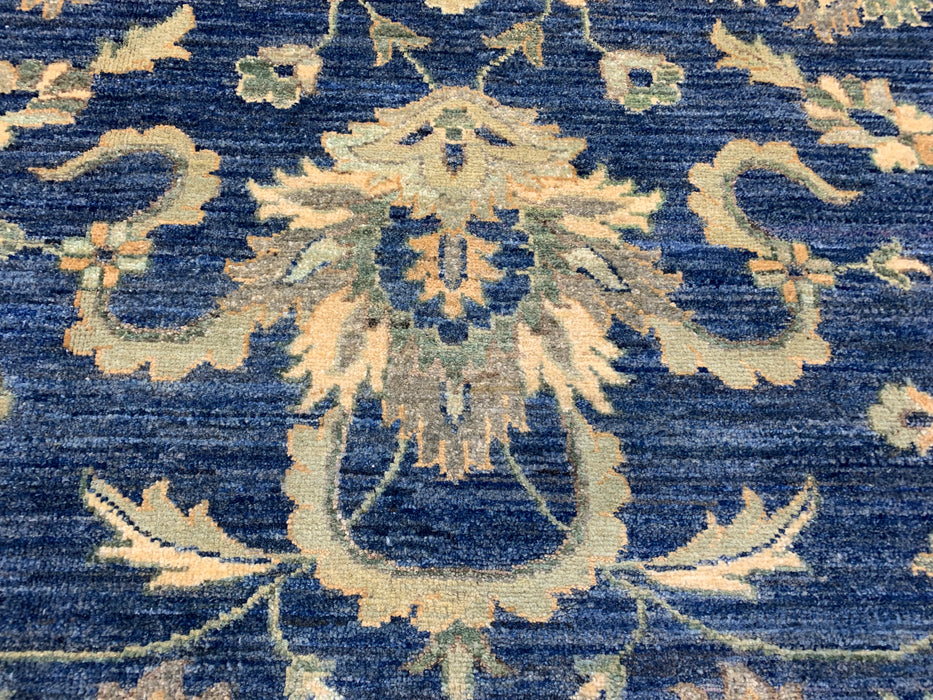 147 × 198 cm handgeknoopt wollen tapijt – marineblauw met bloemrijke rand in zacht beige en saliegroen