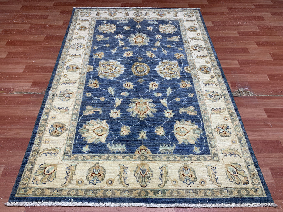 122 × 180 cm handgeknoopt wollen tapijt – marineblauw met bloemmotief in ivoorwit