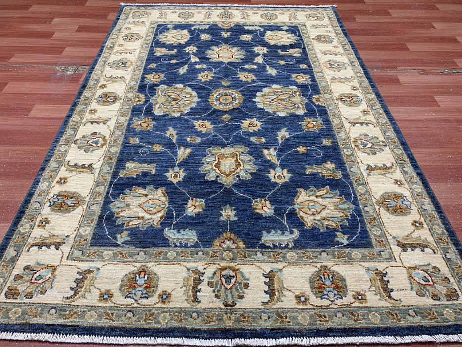122 × 180 cm handgeknoopt wollen tapijt – marineblauw met bloemmotief in ivoorwit