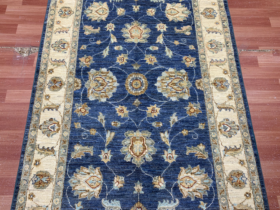 122 × 180 cm handgeknoopt wollen tapijt – marineblauw met bloemmotief in ivoorwit