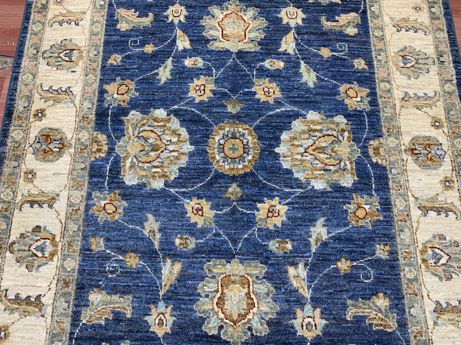 122 × 180 cm handgeknoopt wollen tapijt – marineblauw met bloemmotief in ivoorwit